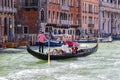 Water channels of Venice city. Gondolier rolls tourists on the gondola on Grand Canal in Venice, Italy.