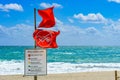 Water Closed to Public red warning flags and informational sign in front of rough, choppy ocean - Hollywood, Florida, USA