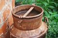 WATER COLLECTED IN LID OF OLD RUSTED MILK CAN IN A COUNTRY GARDEN