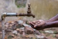 Water crisis is a serious threat to India and worldwide,a man holding his hand under the tap for water Royalty Free Stock Photo