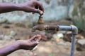 Water crisis is a serious threat to India and worldwide,a man holding his hand under the tap for water Royalty Free Stock Photo