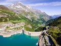 Water dam and reservoir lake aerial view in Alps mountains generating hydroelectricity. Low CO2 footprint, decarbonize, renewable