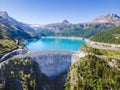 Water dam and reservoir lake aerial view in Alps mountains in summer generating hydroelectricity. Low CO2 footprint, decarbonize,