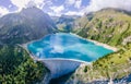 Water dam and reservoir lake in Swiss Alps mountains producing sustainable hydropower, hydroelectricity generation, renewable