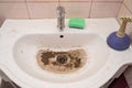 water drains into the dirty sink drain after the blockage is removed Royalty Free Stock Photo