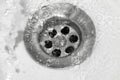 Water drains into the sink, sink and running water for the background, takes care of the water Royalty Free Stock Photo