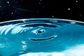 Water drop on blue background. Blue water surface with splash. Clear Waterdrop with circular waves. Splashes closeup. Water splash Royalty Free Stock Photo