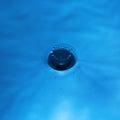 Water drop falling into water making a perfect droplet splash in blue Royalty Free Stock Photo