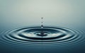 Water drop falling into water with ripples and waves in the background Royalty Free Stock Photo