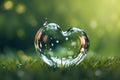 heart shaped water bubble with drop on green grass background