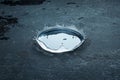 Water Drop Impact on Dark Surface A single water drops impact creating a crown splash reflects surface tension ripples an Royalty Free Stock Photo