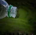 A water drop in opening of water bottle in natural background.