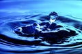 Water drop and ripples shot on nice blue background. Royalty Free Stock Photo