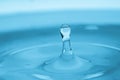 Water drop splash in a glass blue colored Royalty Free Stock Photo