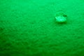 water drop on top of white fabric sheet with green light Royalty Free Stock Photo