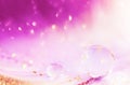 Water drop, transparent bubble and golden glitter on feather background. Beautiful artistic image toned in pink color with sparkle Royalty Free Stock Photo