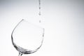 Water drop into wine glass on white Royalty Free Stock Photo