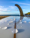 Surfboard Fin with Water Drops on a Sunny Beach Royalty Free Stock Photo