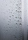 Water droplets cover a smooth, transparent surface, creating a pattern of varying Royalty Free Stock Photo