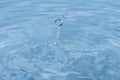 Water droplets falling into clear blue water