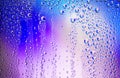 Water droplets condense on the colorful glass surface