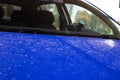 Water droplets on the hood of a blue car Royalty Free Stock Photo