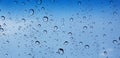 Water droplets perspective through window glass surface against blue sky good for multimedia content Royalty Free Stock Photo