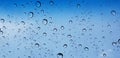 Water droplets perspective through window glass surface against blue sky good for multimedia content Royalty Free Stock Photo