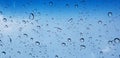 Water droplets perspective through window glass surface against blue sky good for multimedia content Royalty Free Stock Photo