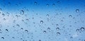 Water droplets perspective through window glass surface against blue sky good for multimedia content Royalty Free Stock Photo
