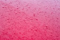 Water droplets from rain on a red metal hood of a car. Rain drops on red car hood. Selective focus Royalty Free Stock Photo