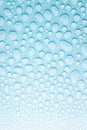 Water droplets on soft light aqua blue background as fresh cold color pattern, texture of shine different form drops with gradient Royalty Free Stock Photo