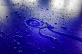 Water droplets on waterproof surface of the car vinyl film are blue purple Royalty Free Stock Photo