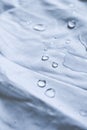 Water droplets on white fabric drapery with folds shining in light Royalty Free Stock Photo