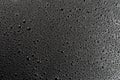 Water drops on abstract flat black hydrophobic surface macro background Royalty Free Stock Photo