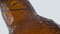 Water drops beer bottle flowing in super slow motion closeup. Cold alcohol drink Royalty Free Stock Photo