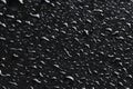 Water drops on black glass surface, closeup Royalty Free Stock Photo