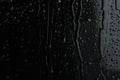 Water drops on black glass surface, closeup Royalty Free Stock Photo