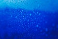 Water drops on blue surface, abstract bright background texture Royalty Free Stock Photo