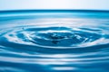 Water drops on blue surface. Water ripple background. Splashes from a drop of water. Raindrops on a blue background. The texture