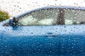 Water drops on the car window. View from car with raindrops on the window to next car with blue color. Rainy day Royalty Free Stock Photo