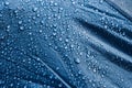 Dark blue rainproof tent sheet with morning rain drops. Royalty Free Stock Photo