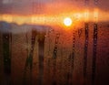 Water drops flowing down window glass at sunset Royalty Free Stock Photo