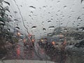 Water drops in front of car mirror with blur traffic on road in raining day Royalty Free Stock Photo