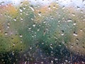 Water drops on glass with autumn trees on the background. Rain drops on the window glass. Autumn yellow leaves in background. Royalty Free Stock Photo