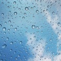 Water drops on glass with blue sky and clouds background. Abstract texture Royalty Free Stock Photo