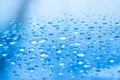 Water drops on glass with blurred blue sky background , rain in the city Royalty Free Stock Photo