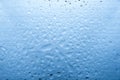 Water drops on glass with blurred blue sky background , rain in the city. Royalty Free Stock Photo