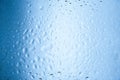 Water drops on glass with blurred blue sky background , rain in the city Royalty Free Stock Photo