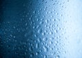 Water drops on glass with blurred blue sky background , rain in the city Royalty Free Stock Photo